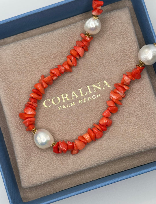 A Red Sardinian coral necklace accented by three baroque pearls and a 14K gold clasp laying in a custom Italian Coralina box. 