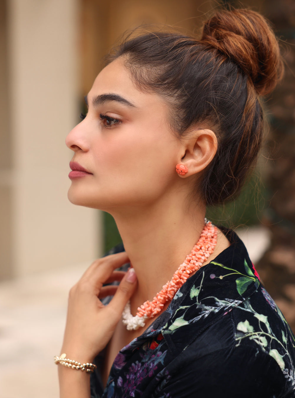 Girl wearing rich red Mediterranean coral Crab earrings and a triple strand pink and white coral necklace. 