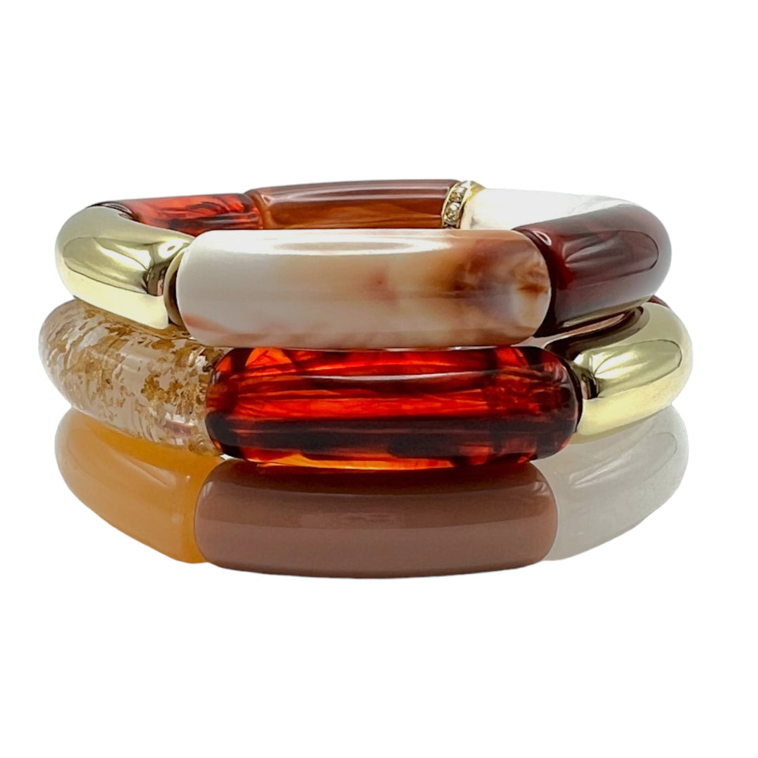 Gold, amber, and beige beaded resin bracelet stack with a diamond rhinestone roundel. 