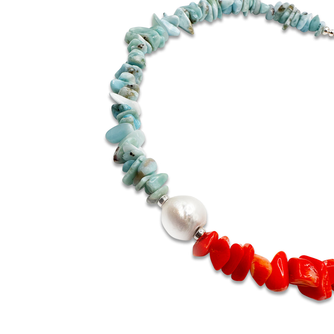 Red Mediterranean coral and blue Larimar necklace offset by a large white baroque pearl and finished with 925 sterling silver. 