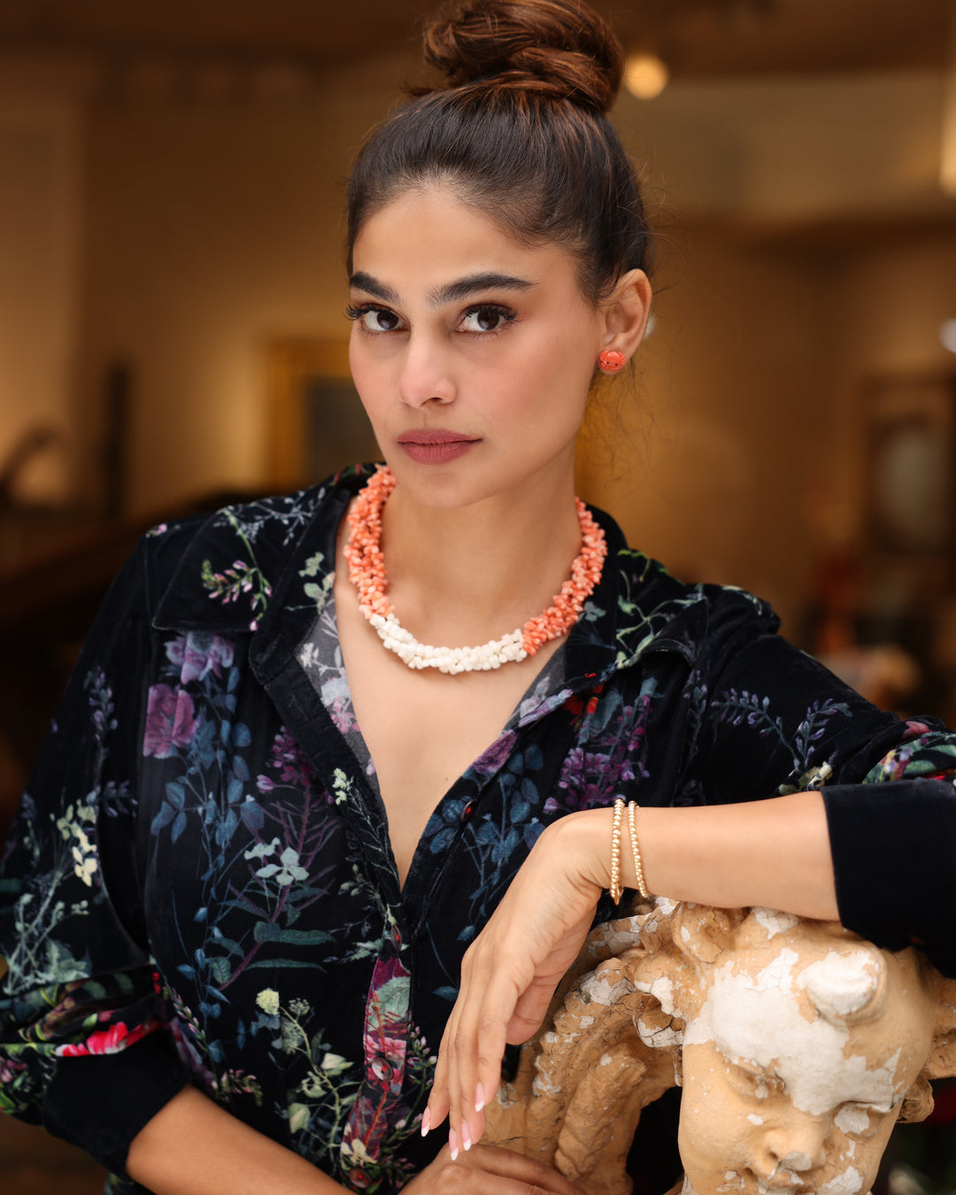 Girl in Palm Beach wearing a triple strand necklace of pastel pink/peach and bright white coral twisted and finished with sterling silver. She is also wearing coral crab earrings and 14K gold Coralina bracelets. 