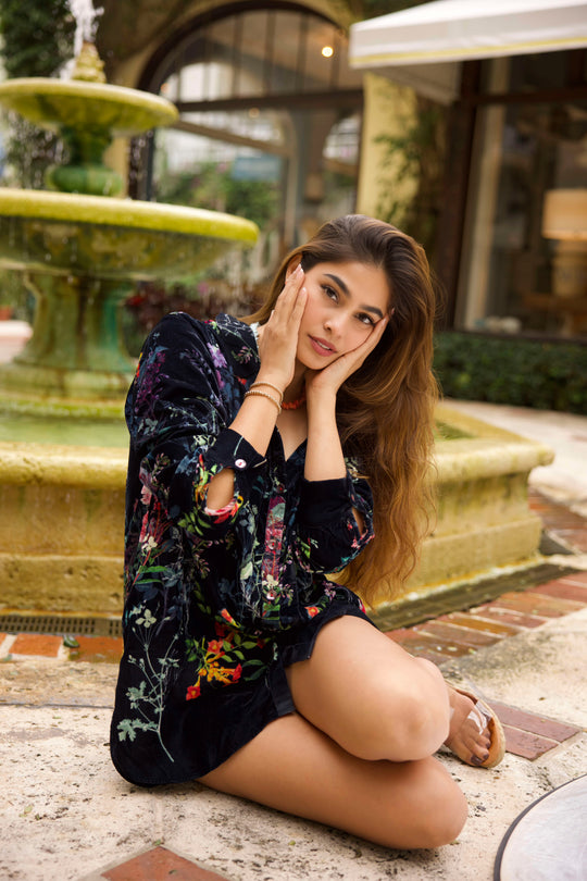 Girl sitting on the ground in Palm Beach wearing two 14K gold beaded bracelets. 