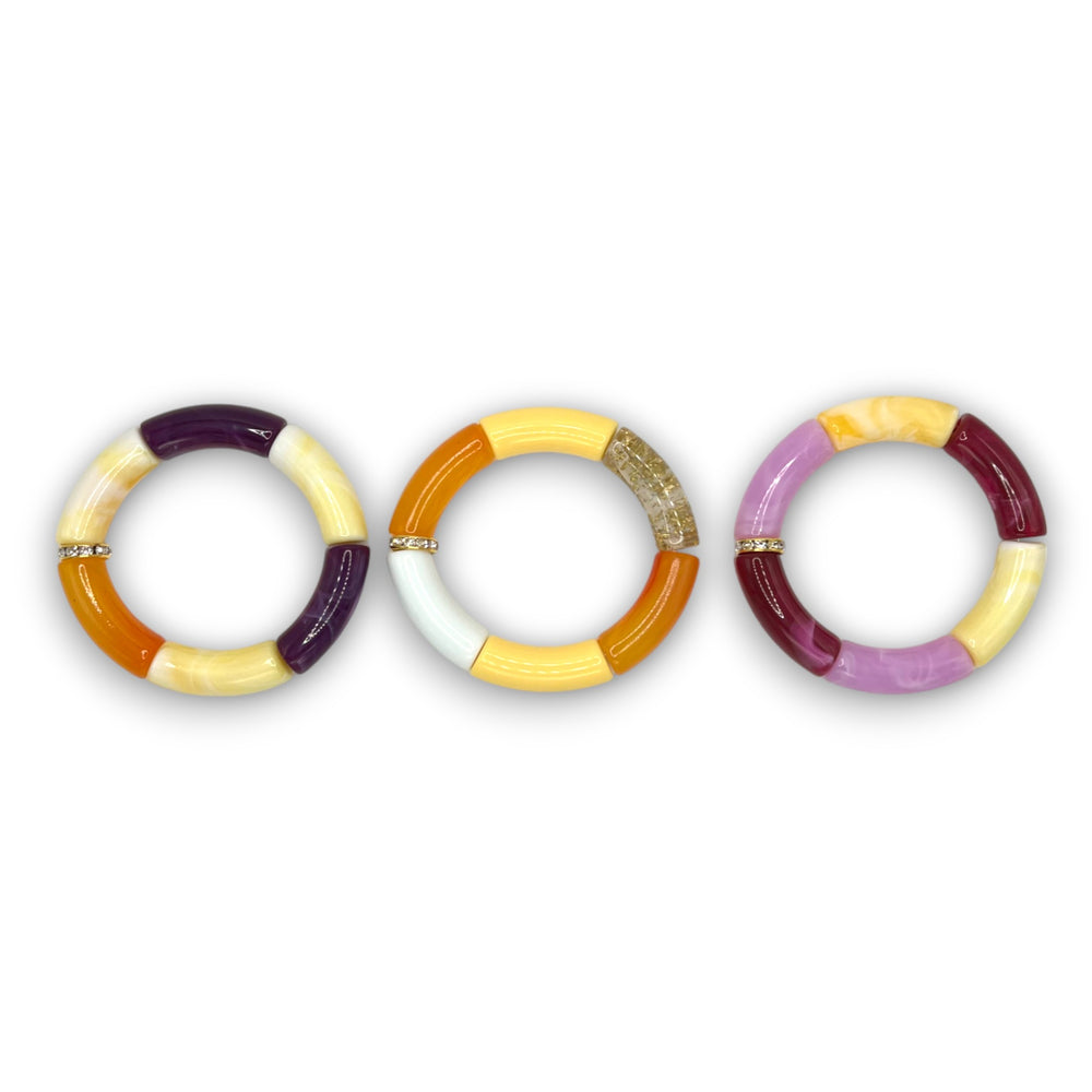 Three yellow, orange and purple beaded resin stretch bracelets with a diamond rhinestone roundel. 