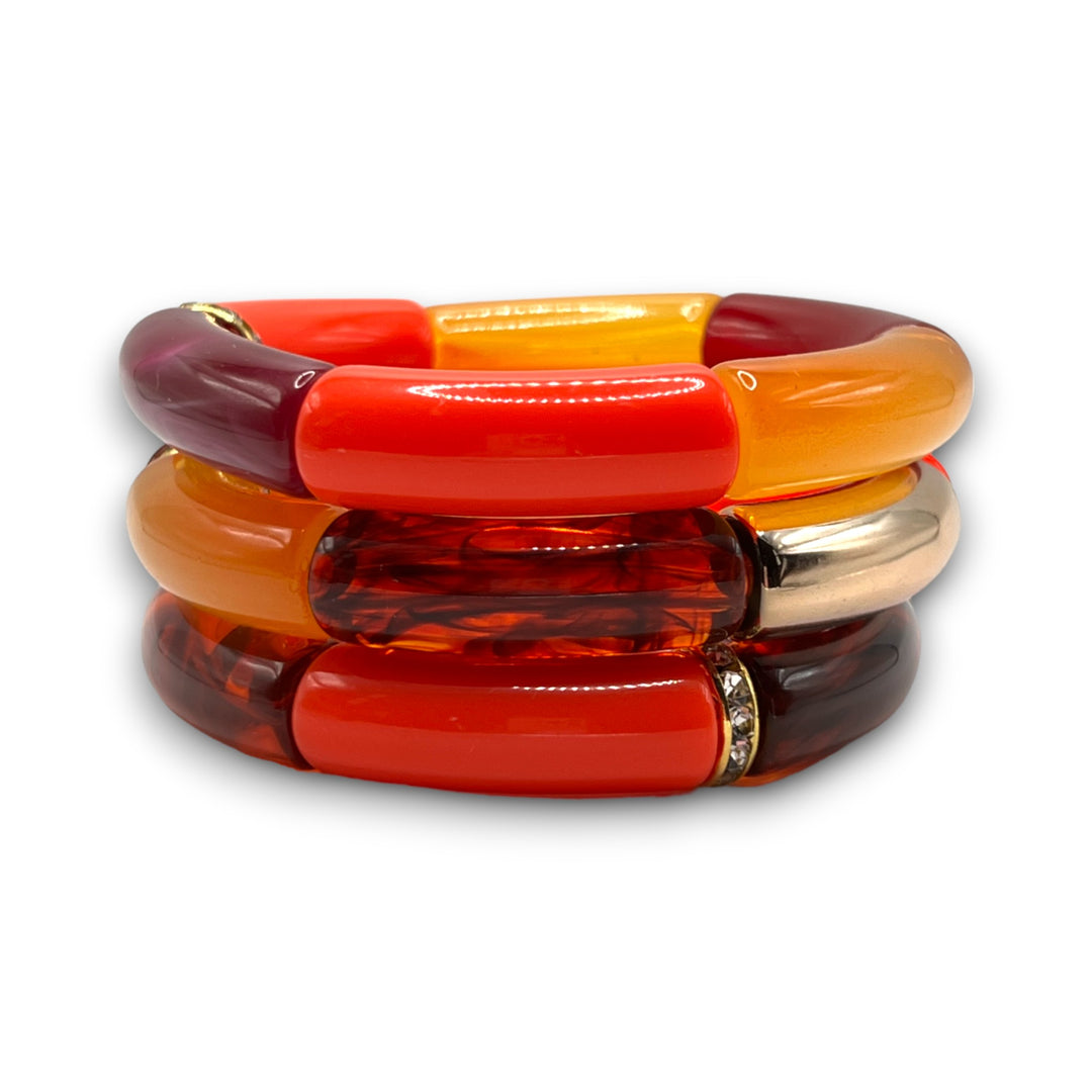 Three bright red, amber and gold beaded resin stretch bracelets with a diamond rhinestone roundel. 