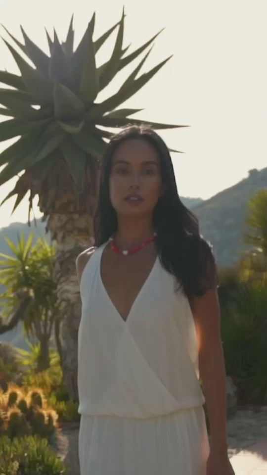 Girl in a garden wearing a red Sardinian coral necklace accented by three baroque pearls and a 14K gold filled clasp. 