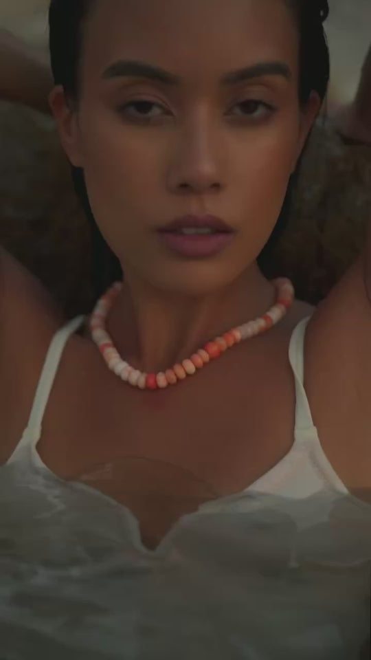 Girl in water wearing an orange opal candy necklace. 